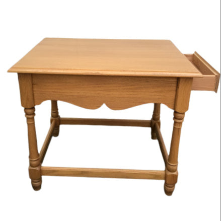 Wooden side table with a drawer in front of a white garage door