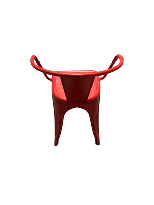 Red metal chair on a concrete floor with people and clothes in the background
