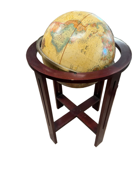 World globe on a wooden stand in a room with furniture.