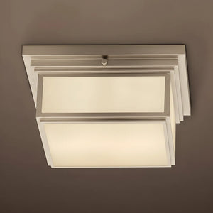 Modern ceiling light fixture with white glass shades on a brown background