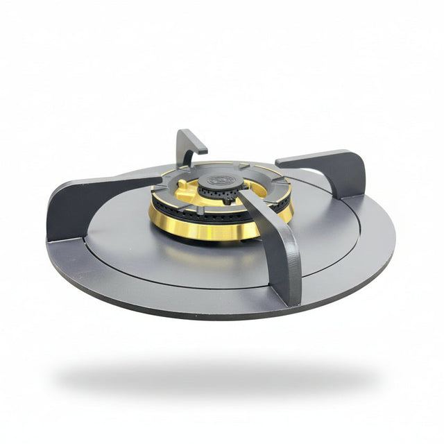 A portable folding camping gas stove with a black base, dark gray burner grates, and a gold burner head, shown on a beige carpeted floor against a white wall.