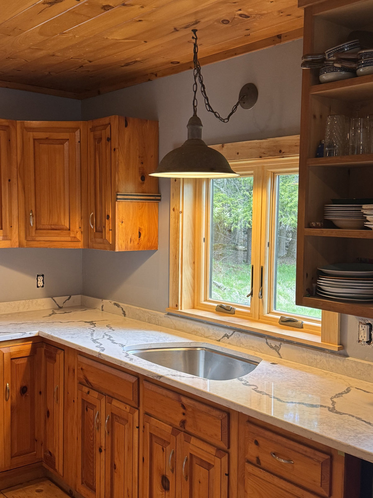 After: Franke Centennial undermount sink set in veined Viatera quartz beneath the kitchen window
